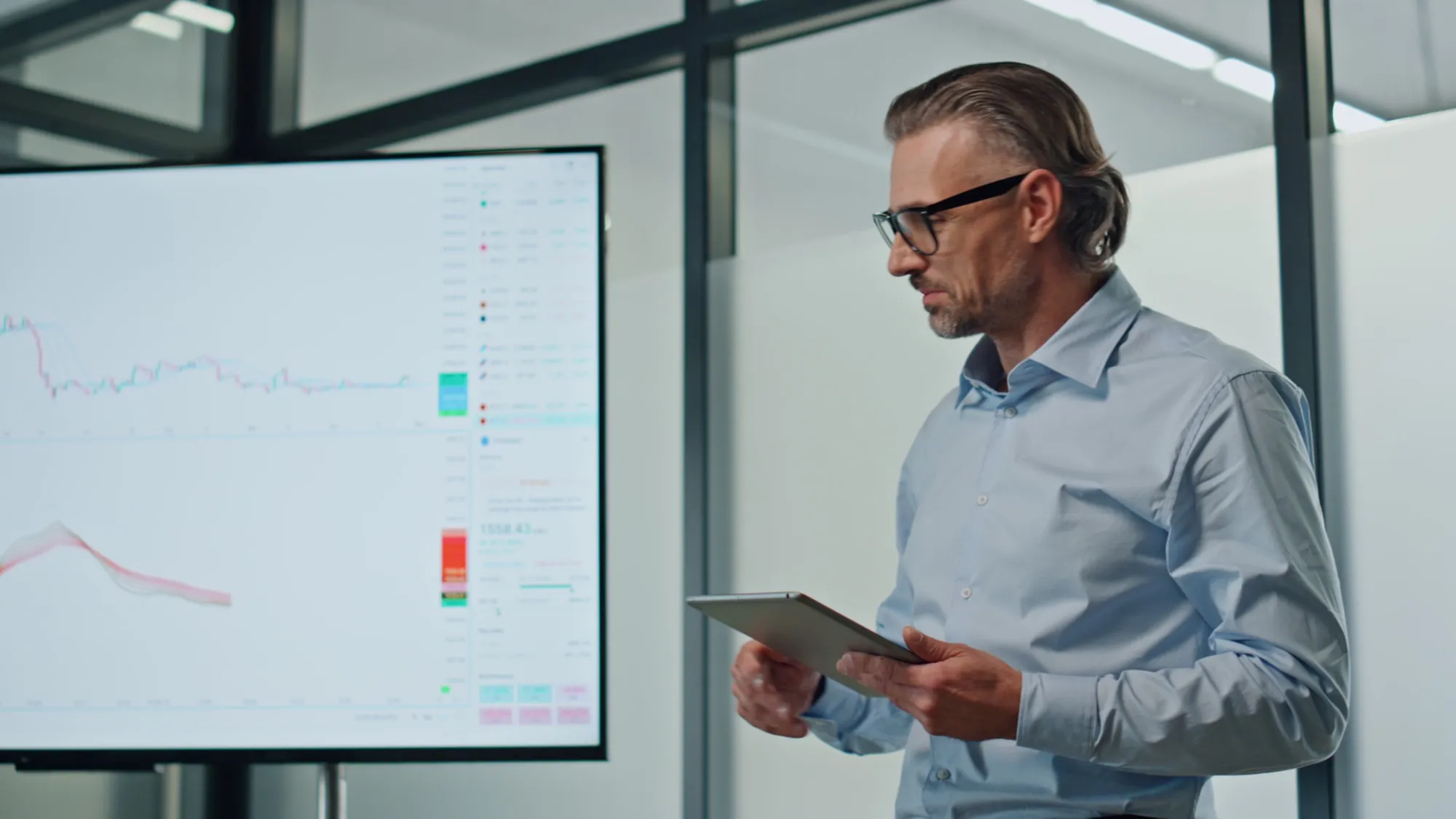 Person betrachtet Diagramme auf einem Tablet