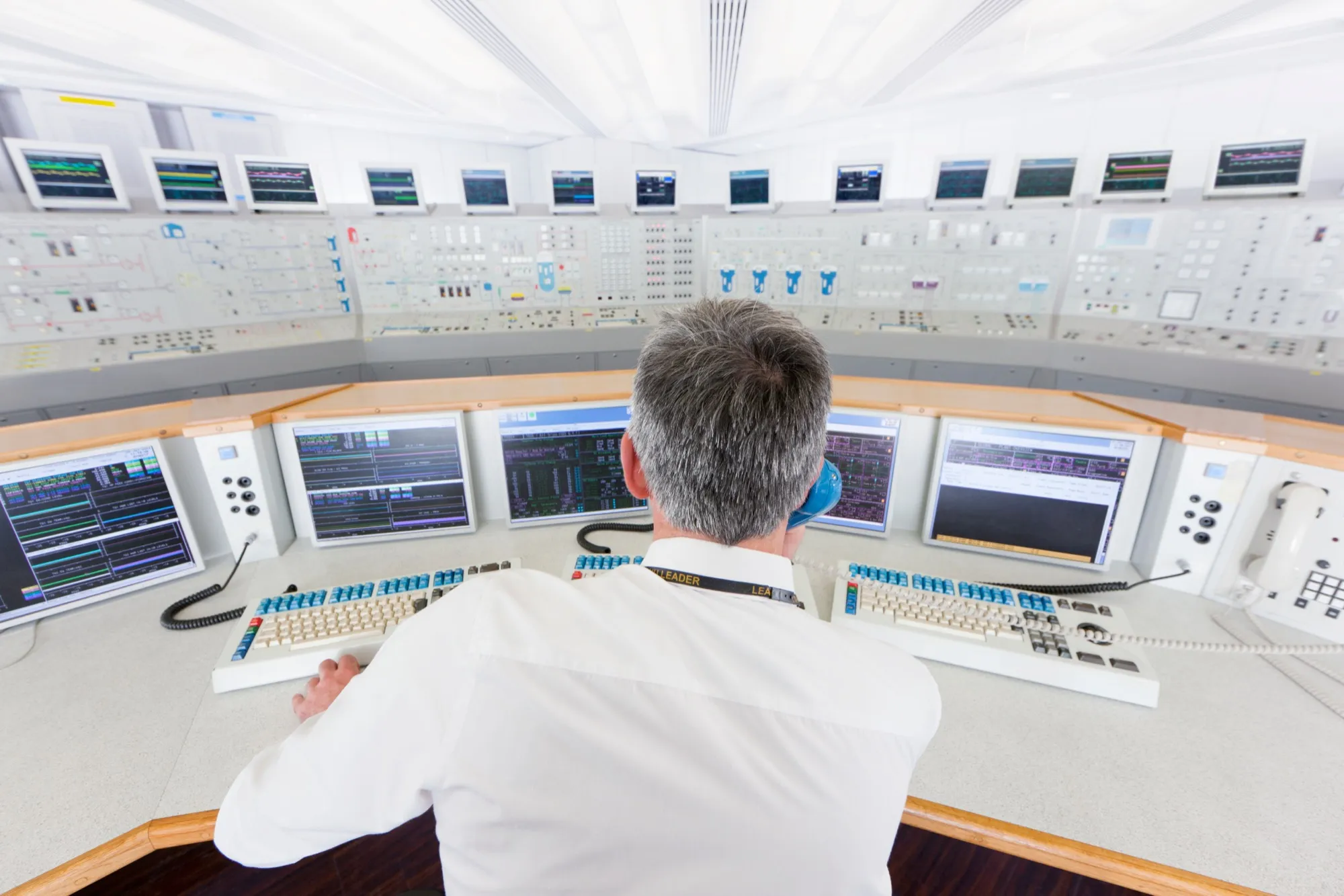 Ingenieur an einem Leitstand mit Monitoren